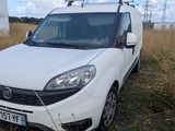 a small white van parked in a field of tall grass
