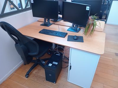 un bureau sur lequel sont posés deux écrans d'ordinateur et un clavier