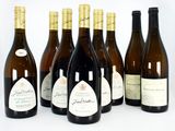 six bouteilles de vin sont alignées sur une surface blanche