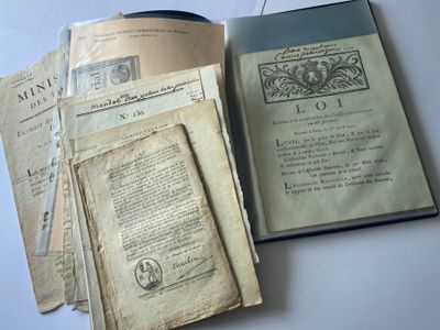 un livre ouvert posé sur une table, à côté d'une pile de vieux livres