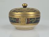 an image of a gold and black bowl on a white surface