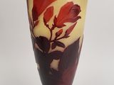 a vase with a red flower on it on a black stand