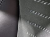 a close up of a black leather seat with stitching on it