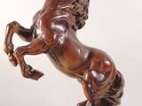 statue en bronze représentant un cheval dressé sur ses pattes arrière, posée sur un socle