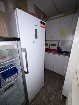 un réfrigérateur blanc dans une petite cuisine équipée d'un plan de travail