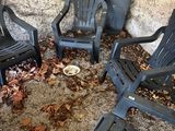 four plastic lawn chairs sitting in a circle on the ground