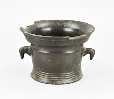 un petit vase en bronze à deux anses sur fond blanc