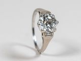 a close up of a diamond ring on a white surface