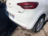 the rear end of a white car parked in a parking lot