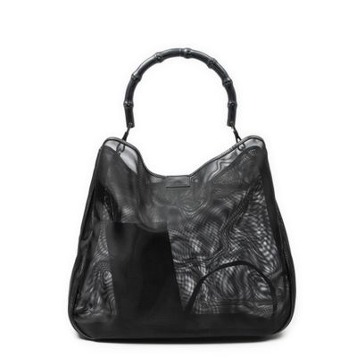 un sac à main noir muni d'une poignée en bambou sur fond blanc