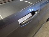 a close up of a car door handle with a sticker on it