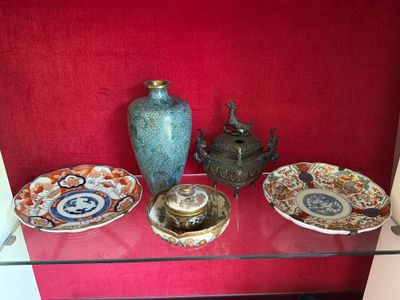 une étagère en verre sur laquelle sont posées des assiettes et des vases