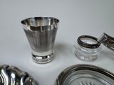 a silver cup sitting on a table next to a clock