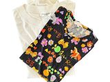 Deux t-shirts ornés de fleurs sont posés l'un à côté de l'autre