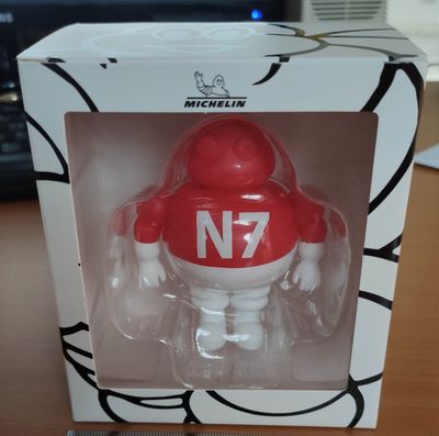une figurine rouge et blanche dans une boîte posée sur une table