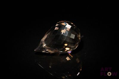 un gros plan d'un diamant posé sur une table, sur fond noir
