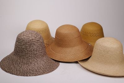 plusieurs chapeaux sont alignés sur une surface blanche