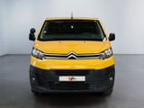 yellow citrole van parked in a large room with a white wall