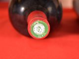 two bottles of wine sitting on a red cloth