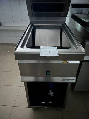 un lave-vaisselle en acier inoxydable posé au milieu d'un sol carrelé