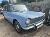 une petite voiture bleue garée devant un mur