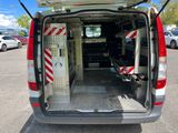 the back of a silver van with its doors open in a parking lot
