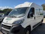 une camionnette blanche garée sur un parking, avec d'autres véhicules en arrière-plan