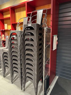 de nombreuses chaises empilées les unes sur les autres dans un magasin