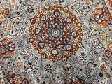 a close up of a blue and red rug on a wooden floor