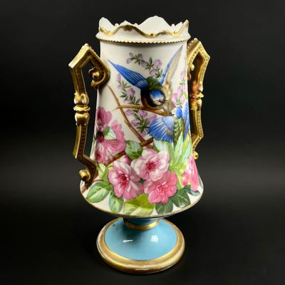 un vase orné d'un oiseau et de fleurs