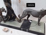 three statues of a woman and two dogs on a table