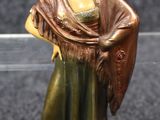 figurine représentant une femme portant un châle, sur fond noir