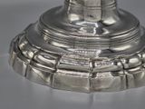 a silver plate with a bell on it on a table