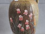 a brown vase with pink flowers painted on it