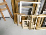 a lot of picture frames and a ladder in a room