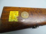 a close up of a wooden rifle with a brass plate on it