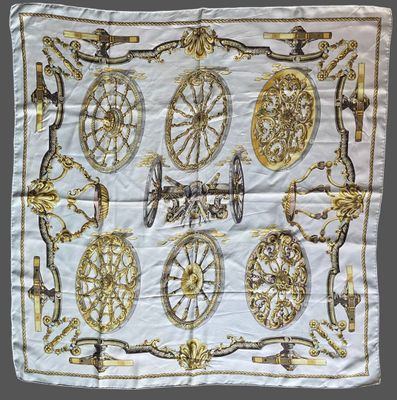 a close up of a white and gold scarf on a table