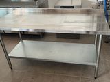 a stainless steel table in the middle of a kitchen