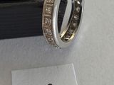 a close up of a ring with diamonds on a white surface