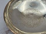 a silver plate on a marble table with a silver handle