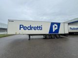 the semi trailer is parked in front of a large building