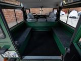a green bus that is parked in a parking lot