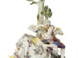 une image représentant une figurine d'un homme et d'une femme assis sous un arbre