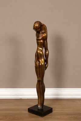 statue en bronze représentant un homme tenant un bébé dans ses bras, posée sur un socle noir