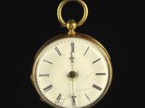 a gold pocket watch with roman numerals on the face