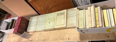 de nombreuses caisses de livres posées sur une table dans une pièce