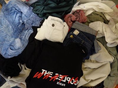 a pile of clothes that is sitting on a bed