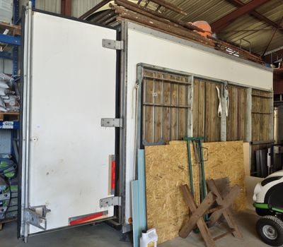 une photo d'un garage dans lequel se trouvent un tracteur et une remorque