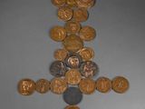 a cross made out of coins on a table