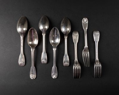 six silver spoons and two silver spoons on a black surface